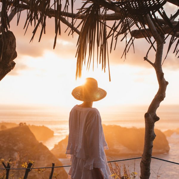 Young girl looking at the sunset with multiple islands in the background